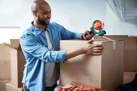 Person sealing box with HD Clear Packing Tape Dispenser Heavy Duty Tape Gun for Boxes Shipping and Moving, includes one refill roll, foam handle