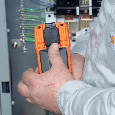 Electrician using Digital Manual-Ranging 600V AC/DC Voltage Tester multimeter near electrical panel for continuity testing.