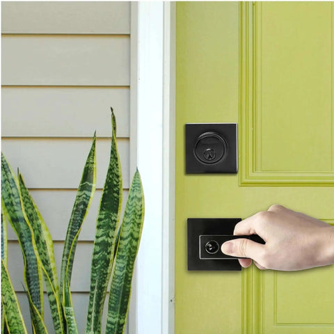 Hand using Matte Black 3 Pack Exterior Door Lock Set With Deadbolt And Front Door Handle Set Keyed Alike on yellow door