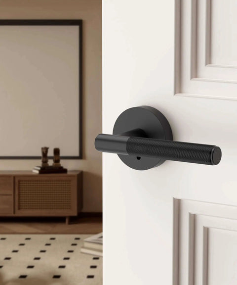 Matte black privacy door handle with lock on a white interior door, part of a 4 pack for bedrooms or bathrooms, reversible and keyless.
