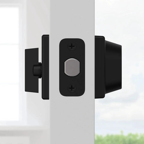Side view of 660 Deadbolt Lock Matte Black Single Cylinder with keyed exterior, installed on a white door against a blurred background.