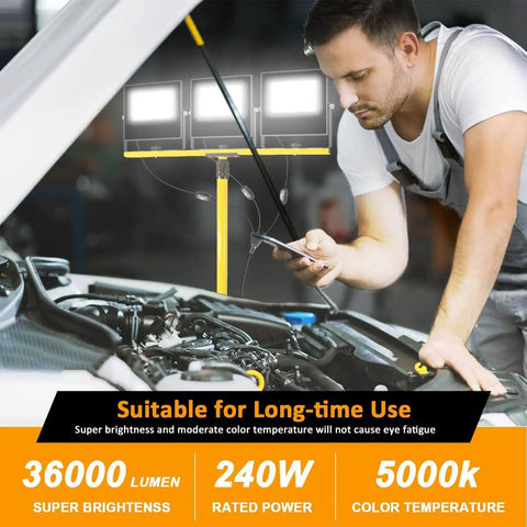 Ultra Bright 36000 Lumen LED Work Light With 3 Foldable Heads On A Sturdy Stand 16 Ft Cord IP67 Waterproof Tripod For Indoor Outdoor Job Sites Garage Construction Site And Workshop Lighting illuminating a mechanic working on a car engine.
