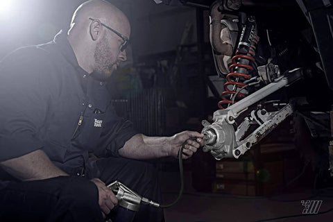 Mechanic using 44mm Wheel Bearing Greaser For Polaris RZR 900 1000 And Pro XP Jansen Motorsports on a UTV suspension