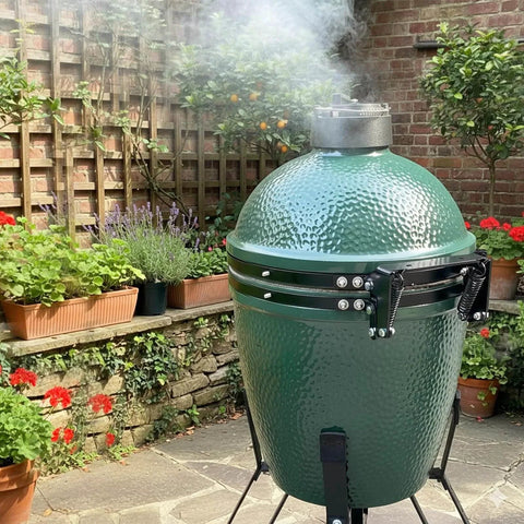 Medium Big Green Egg grill with hinge assembly replacement kit, showing powder coated steel hinge and spring in a garden setting.