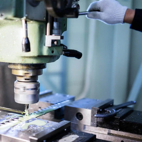 Person operating milling machine with adjustable screw jack set for precise leveling, supporting heavy equipment.