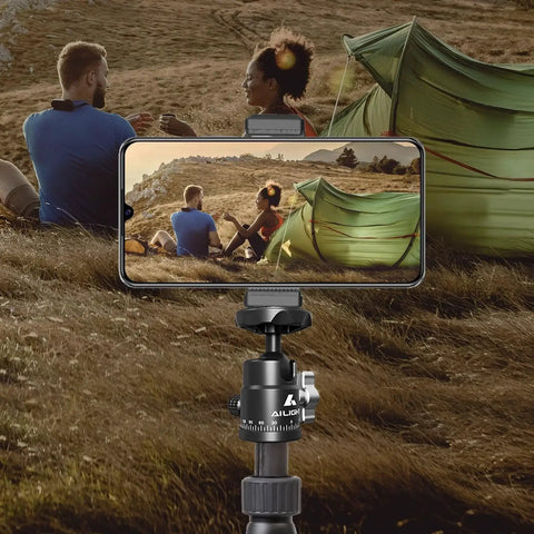 Two Pack Mini Ball Heads With 360 Degree Pan And 135 Degree Tilt Locking Knob Rubber Base Pad To Prevent Scratches Universal One Quarter Inch To Three Eighths Inch Screw Adapters Dual Cold Shoe Mounts For DSLR Cameras And Camcorders showing smartphone on tripod recording two people by tent