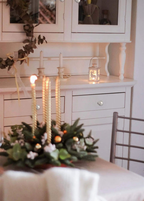Cozy dining room with festive candle centerpiece and white cabinet backdrop