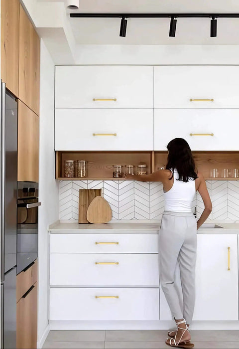 Woman reaching for cabinet with Brushed Gold Cabinet Pulls 5 Inch 128mm Pack Of 10 Kitchen Cabinet Handles in modern kitchen