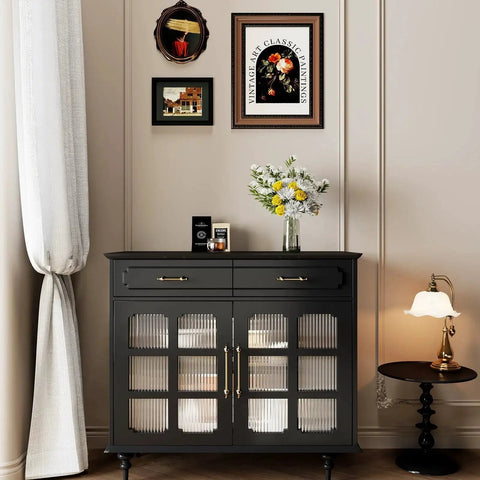 Black cabinet with glass doors and bronze handles, decorated with flowers, in a classic-themed room with framed art on the wall.