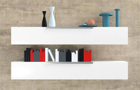 Two white wall-mounted shelves on a concrete wall, decorated with colorful books and modern vases.