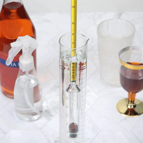 Moonshine Alcohol Hydrometer Kit 0 To 100 Proof With Glass Cylinder Brush And Dust Cloth for Home Distilling displayed on a counter.