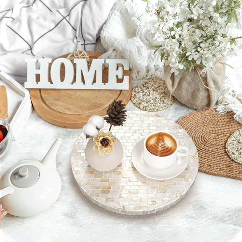 12 inch mother of pearl lazy susan turntable with marble pattern used as a decorative tray for coffee and flowers on a tabletop.