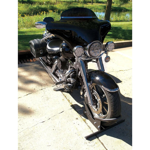 Deluxe Motorcycle Wheel Chock And Tie-Down Kit Extreme Max 5600.3204 holding a motorcycle, outdoor view