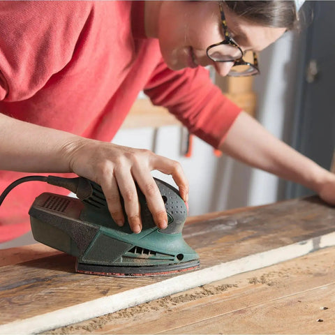 Person using a Ryobi sander with Mouse Sanding Pads Assortment for Ryobi Sander 70 Pc 6 Hole with 40 to 320 Grit on wood surface