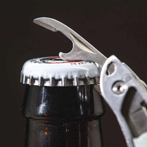 Framework Mini 11 In 1 Multitool Open Frame with bottle opener in use on a bottle cap, showcasing multifunctional capabilities.