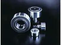 Assorted Single NUCF10-1R uncaged cam follower bearings, shielded metric series, showcasing various sizes and angles on a reflective surface.