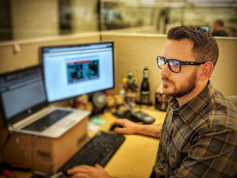 Man at desk wearing ANSI Z87.1 Safety Glasses With Anti Fog UV Protection Clear Lens Side Shields, working on computer