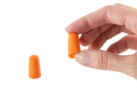 Hand holding soft disposable corded ear plugs pack of 100 pairs with 32 dB noise reduction made from non-toxic skin-friendly foam