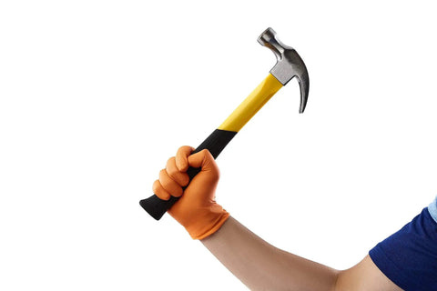 Person wearing Hi-Visibility Orange Nitrile Gloves 8 Mil Thick Diamond Texture Grip 50 Count holding a hammer.