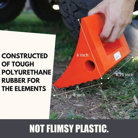 Heavy Duty Wheel Chocks Two Pack That Prevents Movement On Slopes For Boat Trailers RVs Trucks And Campers All Weather Non Slip Solid Rubber With Orange Color By SecurityMan. An orange wheel chock with handle shown in use on grass.