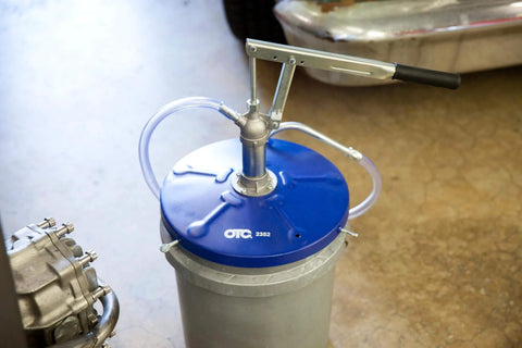 OTC 2352 Lever Action Bucket Pump on 5-gallon pail with hose and handle mechanism for oil distribution