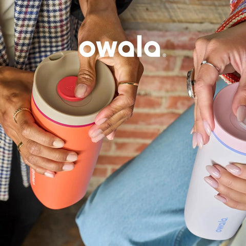 Two people holding insulated stainless steel tumblers with leak-proof SmoothSip slider lids in an outdoor setting.