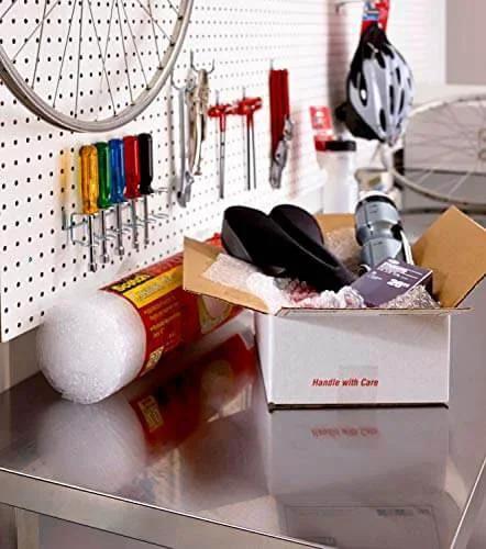 Scotch Sure Start Packing Tape Clear 1.88 In X 22.2 Yd 6 Dispenser Rolls Quiet Unwind Easy Start Strong Hold on a metal workbench with packing supplies.