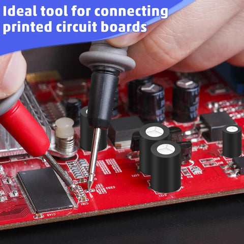 Person using multimeter probes on a red PCB with capacitors and circuits, ideal for connecting printed circuit boards.