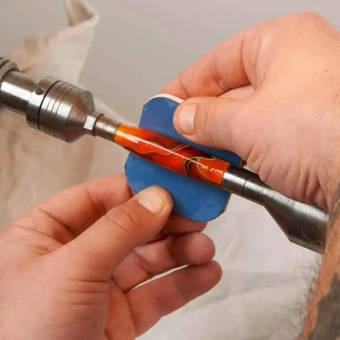 Hands using pen sanding kit with soft touch pads 1500 to 12000 grit for finishing on a pen blank lathe