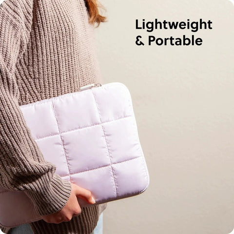 Person holding a petal pink nylon puffy laptop sleeve, medium size, compatible with up to 14 inch laptops, lightweight and portable.