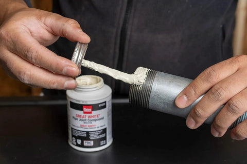 Applying Pro Grade Pipe Joint Compound With PTFE And Brush For Sealing And Lubricating Threaded Joints White Non Hardening Non Toxic Paste
