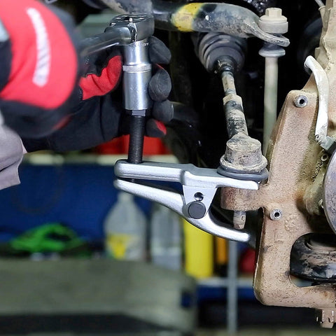 Mechanic using 26554 Front End Service Kit with Pitman Arm Puller on vehicle suspension