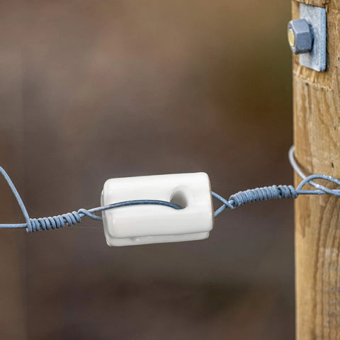 White porcelain bullnose insulator for electric fence wire on wood post