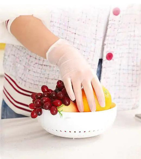 Person wearing Powder Free Vinyl Gloves 4.3 Mil Clear Latex Free For Food Service Cleaning, handling fruit in kitchen.