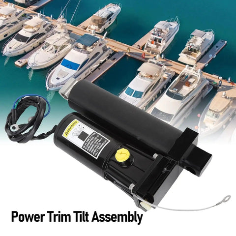 Power trim tilt assembly for outboard motor; black cylindrical unit with yellow cap and wiring, marina boats visible.