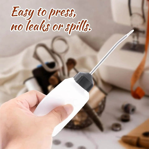 Person holding Two Pack 120ml Sewing Machine Oil Can Set with Precision Long Nozzle Lubricant Dispenser, easy to press, no leaks or spills.