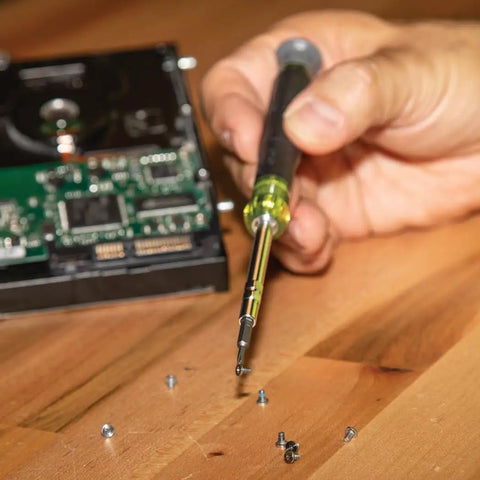 Person using All In One Precision Screwdriver Set With 39 Bits For Apple Devices Magnetic Dual End Barrel For One Handed Fastener Retention Case Included Klein Tools Pro Repair Kit For Tech Enthusiasts on electronics.
