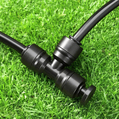 Installed 20 Pack One Quarter Inch End Plugs For Quick Connect Fittings in garden irrigation system on grass with tubing.