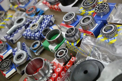 Assorted precision bearings, including Radial Deep Groove Ball Bearing 6416M, arranged for shipping in 3-5 days on a table.