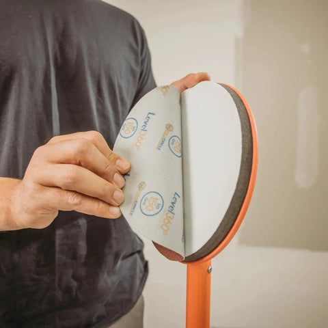 Radius360 Round Sanding Tool With Interchangeable Center Hub 9 Inch in use with sanding pad being attached by hand