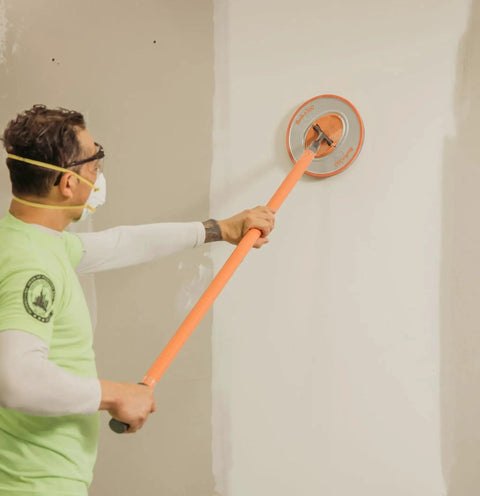 Man using Radius360 Round Sanding Tool With Interchangeable Center Hub 9 Inch on wall surface