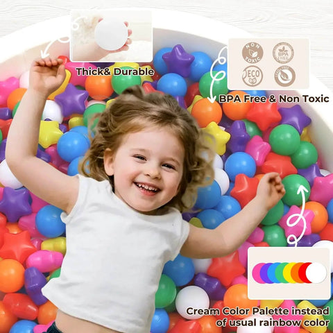 Happy toddler playing in a ball pit filled with colorful star-shaped balls, labeled thick and durable, BPA-free, non-toxic.