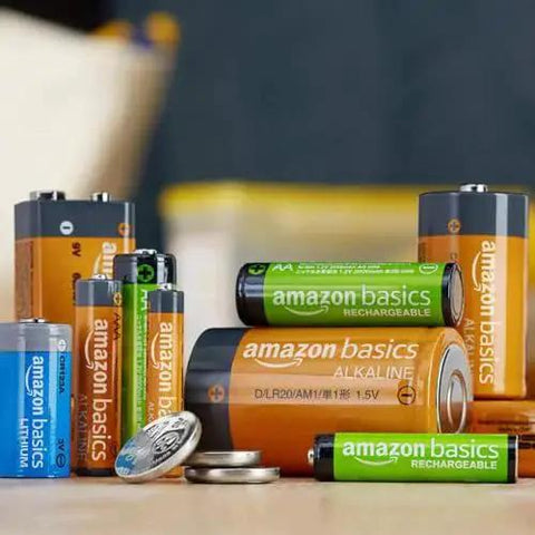 Assorted batteries including Amazon Basics AAA rechargeables, AA lithium, and D cell alkaline, displayed together on a table.