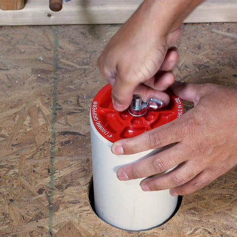 Plastic End Of Pipe Plug With Galvanized Screw And Wing Nut For 4 Inch Red Pipes being installed on pipe end