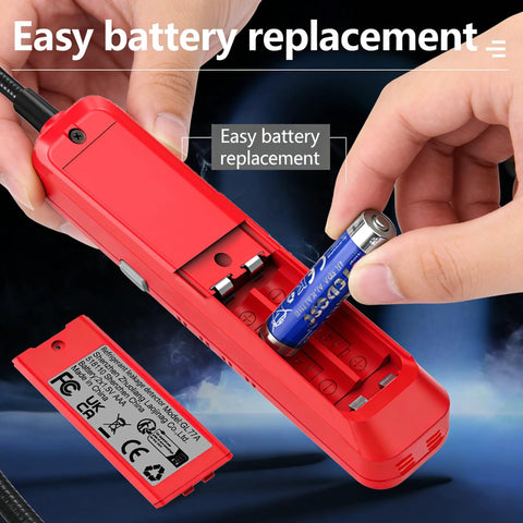 Red handheld Freon leak detector with UV probe; battery compartment open with an AA battery ready to insert.