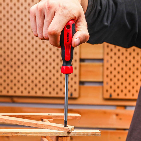Hand using a screwdriver from 158 Piece Home Tool Kit With Plastic Storage Case to fix wooden furniture.
