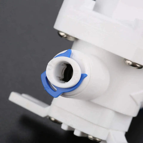 Close-up of RO water pressure regulator and flow regulator for reverse osmosis systems one quarter inch quick connect reducing valve.
