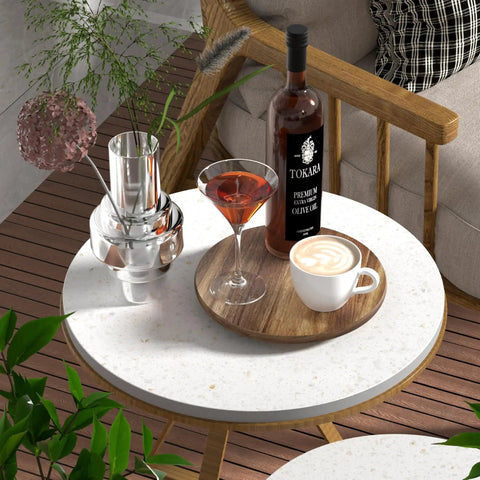 Round patio table with drinks, plant decor, and bottle on wood tray