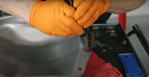 Mechanic applying Ultra Black RTV Silicone Gasket Maker For Engine Sealing With High Flexibility And Oil Resistance on engine part