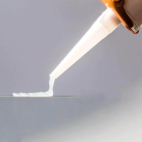 Close-up of Clear One Hundred Percent RTV Silicone Sealant for Vertical and Overhead Installations being applied from a 10.2 oz cartridge.